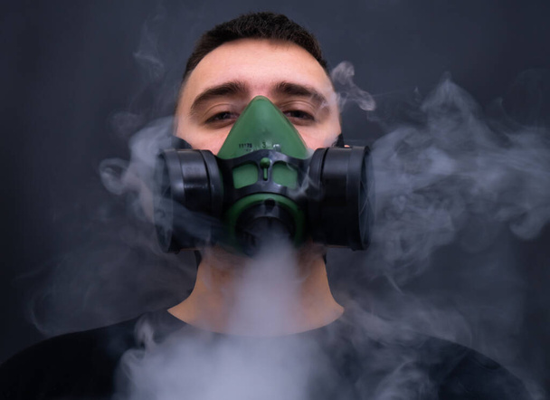 closeup άνδρες που φορούν μάσκα αναπνευστήρα βιομηχανικό φυσίγγιο φίλτρο αντι-σκόνη χημική ασφάλεια με απαλή εστίαση και πάνω από το φως στο παρασκήνιο - Φωτογραφία, εικόνα