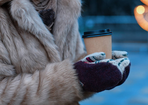 woman in gloves holding cup of coffee  in cold winter day - 写真・画像