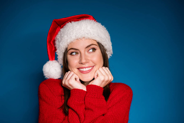 Close up photo positive girl in santa claus hat touch face fists chin guess boyfriend give x-mas christmas fair party celebrate wear pullover isolated gradient blue color background - 写真・画像