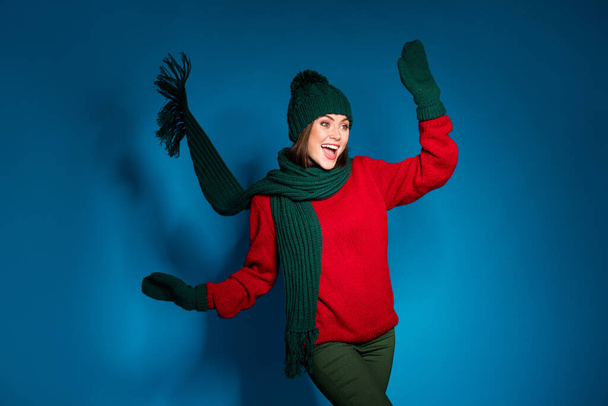 Photo of crazy funky positive girl in winter warm outfit pullover pants trousers woolen mittens enjoy x-mas fairy spirit wind blow raise hands isolated over gradient blue color background - 写真・画像
