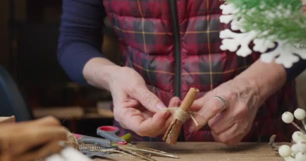 Florist makes the decoration for Christmas from cinnamon bark - Footage, Video