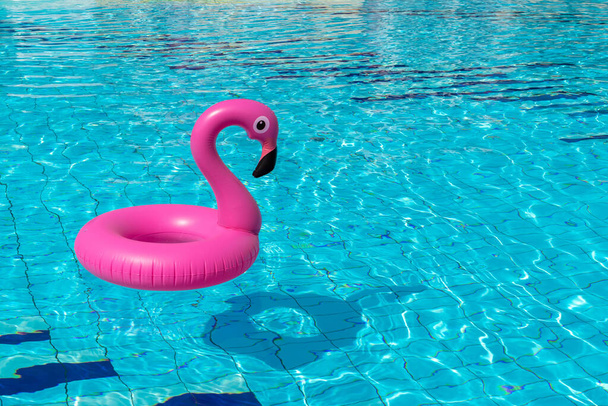 Літній концепт фон. Рожевий надувний фламінго в басейні для літнього пляжного фону. вечірка біля басейну
 - Фото, зображення