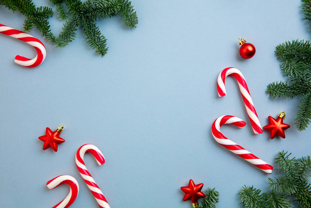 Decoraciones de Navidad bastones de caramelo y estrellas rojas sobre fondo azul. - Foto, imagen