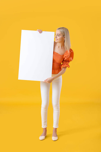Gyönyörű fiatal nő üres poszter színes háttér - Fotó, kép