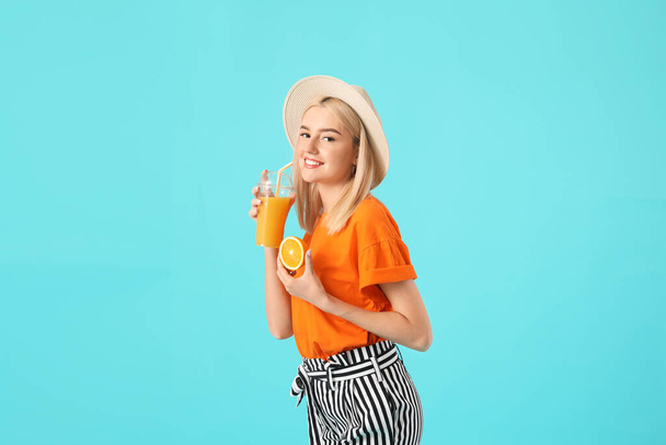 Beautiful young woman with orange juice on color background - Φωτογραφία, εικόνα