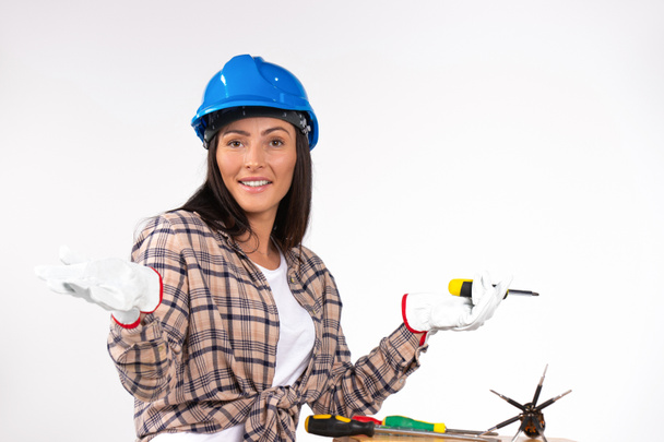Happy woman electrician with screwdrivers and in hard hat posing on white background. High quality photo - Foto, Imagem