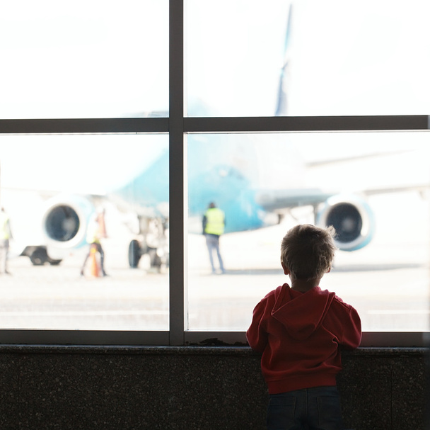 Chico mira el avión en el aeropuerto
 - Foto, imagen