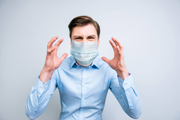 Close-up portrait of annoyed fury guy wearing safety gauze mask mers cov risk panic syndrome isolated on gray color background - Foto, Bild
