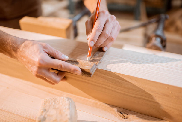 Carpintero trabajando con una madera en el interior - Foto, Imagen