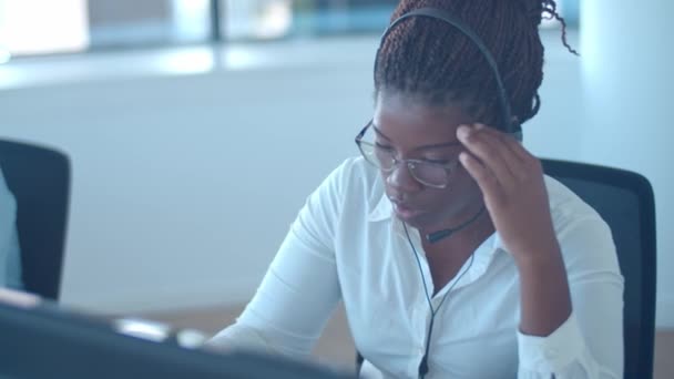 Συναισθηματική African American χειριστή σε ακουστικά λαμβάνοντας κλήση - Πλάνα, βίντεο