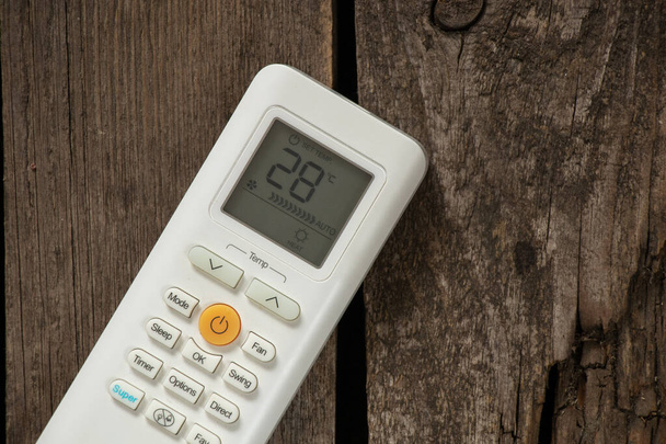 λευκό τηλεχειριστήριο από κλιματιστικό σε ξύλινο φόντο από κοντά - Φωτογραφία, εικόνα