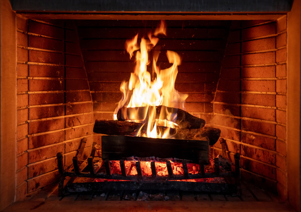 Lareira, queima de fogo, aconchegante lareira quente, feriado casa de Natal. Madeira logs flamejante, tijolos de fundo, vista close-up - Foto, Imagem