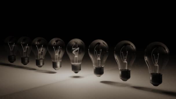 Line of light bulbs with middle light bulb gaining brightness illustrating having an idea. 3D render / animation with black and white background. - Footage, Video