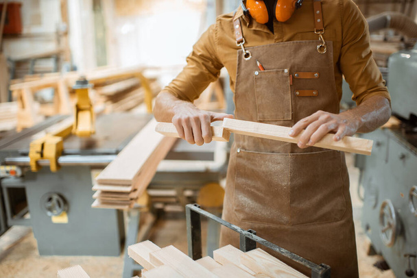 Carpenter working with wooden bars - Photo, Image