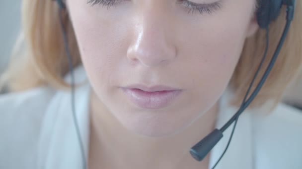 Face of young female call center operator in headset - Filmagem, Vídeo