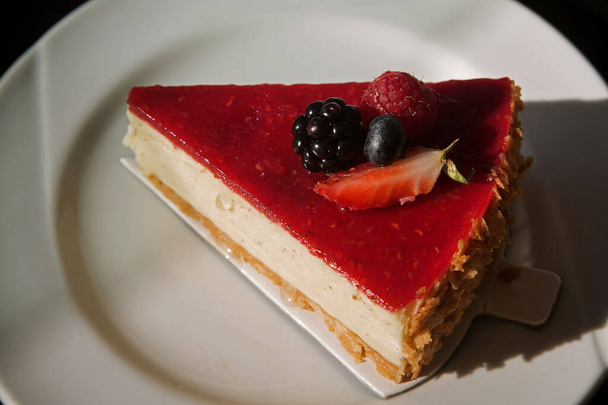 Beyaz tabakta meyveli vanilyalı cheesecake. - Fotoğraf, Görsel