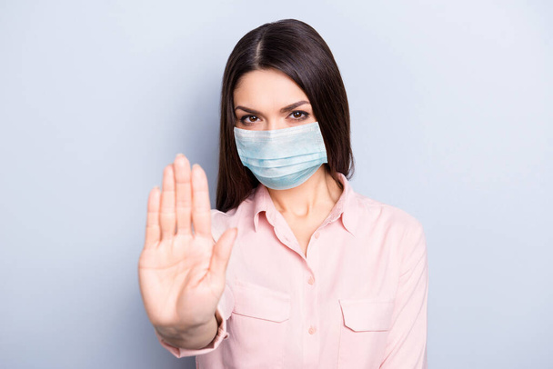 Close-up portrait of attractive strict girl wearing safety gauze mask showing palm stop keep distance isolated on gray color background - Foto, immagini