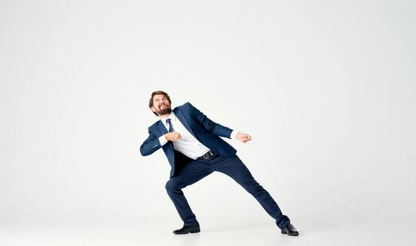 successful business man in a suit pulls an invisible thread on a light background - Photo, Image
