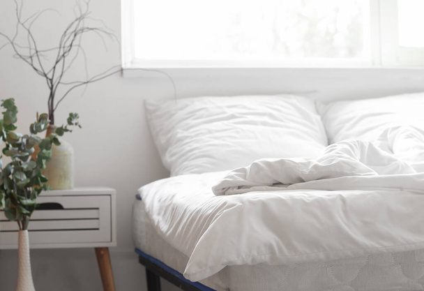 Κρεβάτι με άνετο ορθοπεδικό στρώμα στο δωμάτιο - Φωτογραφία, εικόνα