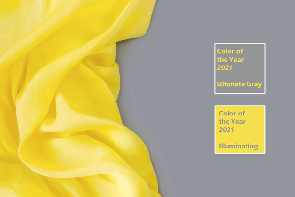 Modny kolor roku 2021. Oświecający Żółty i Ostateczny Szary. Piękne abstrakcyjne tło tkaniny jedwabnej. Przestrzeń kopiowania, płaski układ. - Zdjęcie, obraz