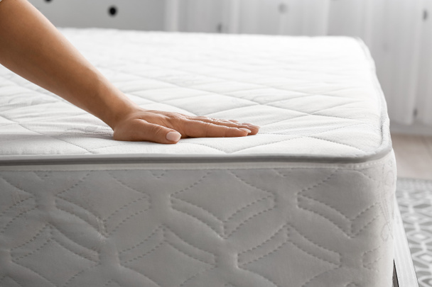 Woman touching soft orthopedic mattress - Foto, Bild