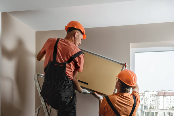 Werknemers installeren een split systeem voor een home air conditioning systeem. - Foto, afbeelding