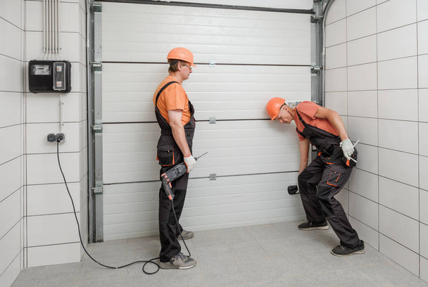 Los trabajadores están instalando puertas de ascensor en el garaje. - Foto, imagen