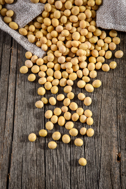 Close-up of soybean on wood background in jute sack. - Photo, Image