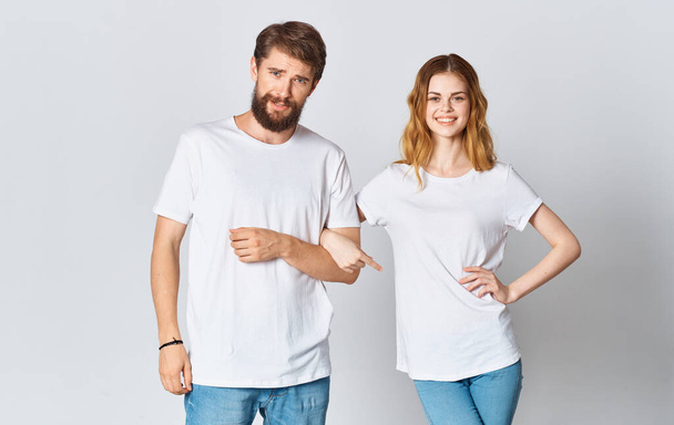emotional man in a t-shirt and a woman in jeans on a light background fabric clothing fashion style - Photo, Image