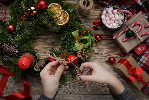 Christmas home decoration, female hands holding a wreath, hand made - Valokuva, kuva