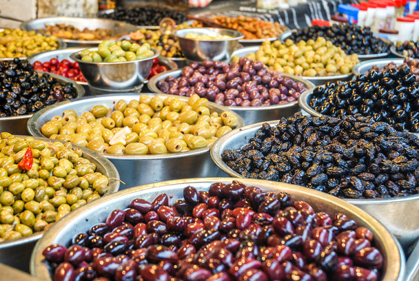 Różne rodzaje oliwek w miskach na stoisku targowym - Zdjęcie, obraz