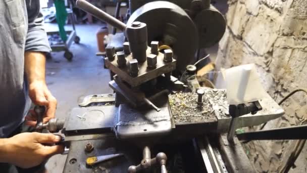 Close up or milling machine in action. Unrecognizable turner working with old workbench in his garage or workshop. Mechanic using lathe for metal processing. Slow motion - Footage, Video