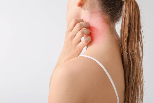 Молода алергія жінка дряпає свою шкіру на світлому фоні
 - Фото, зображення