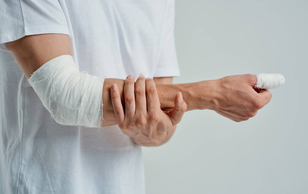 hombre con el brazo vendado codo y el dedo medicina lesión - Foto, imagen