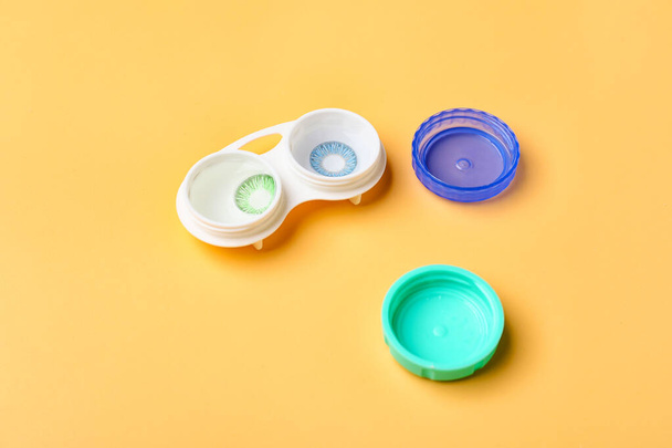 Container with contact lenses on color background - Photo, Image