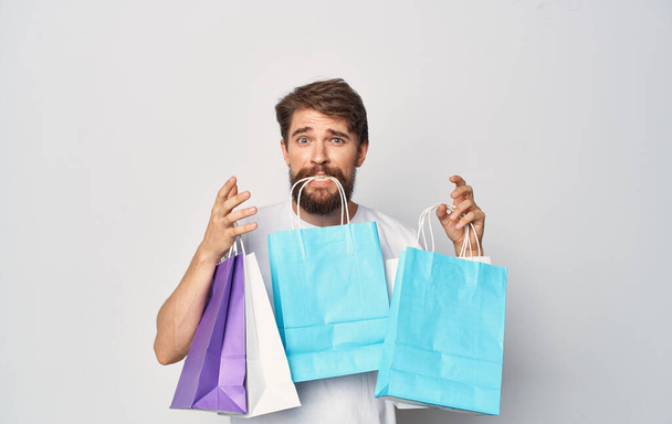 Uomo barbuto in t-shirt bianca con pacchetti in mano shopping vacanza segno isolato - Foto, immagini