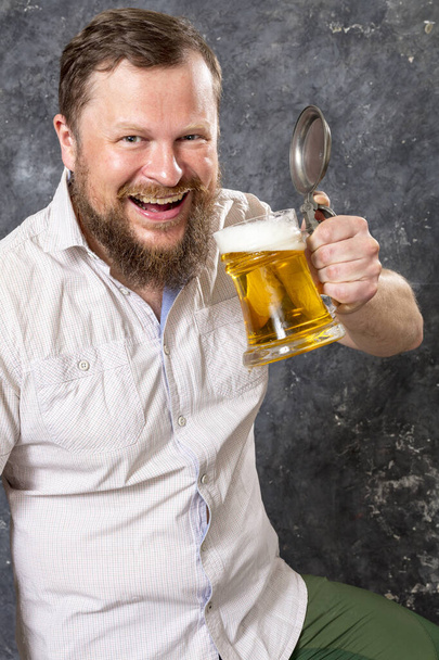Matured smiling bearded man in shirt with beer mug - Photo, image