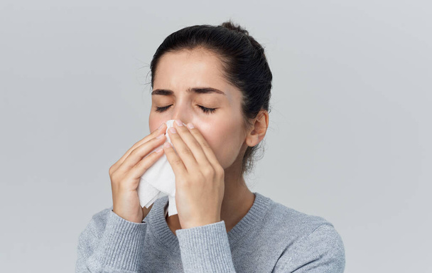 woman blows her nose into a napkin runny nose health problems gray background - Fotoğraf, Görsel
