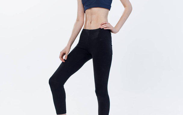mujer en ropa deportiva sobre fondo claro vista lateral leggings camiseta fitness - Foto, Imagen