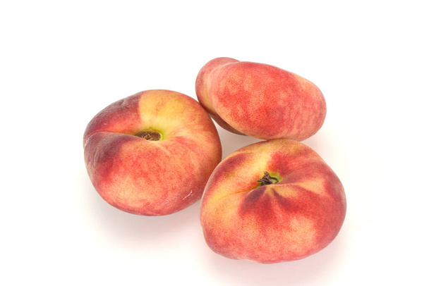 Солодкі стиглі смачні кілька плоских персиків
 - Фото, зображення