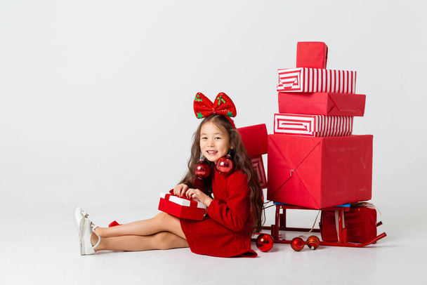 cute asian girl posing with many gifts on white studio background - Φωτογραφία, εικόνα
