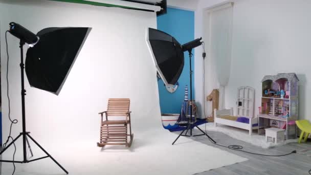Altı köşeli stüdyo ışıkları olan fotoğraf ya da video stüdyosu. Beyaz ekran ve sabitlenmiş sandalye - Video, Çekim
