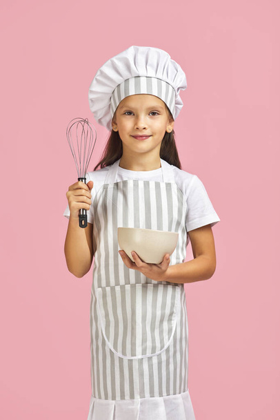little girl mixing something with a whisk in bowl. - Foto, Imagen