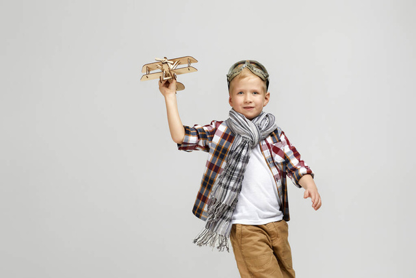 child boy in retro glasses playing with wooden toy airplane - Foto, imagen
