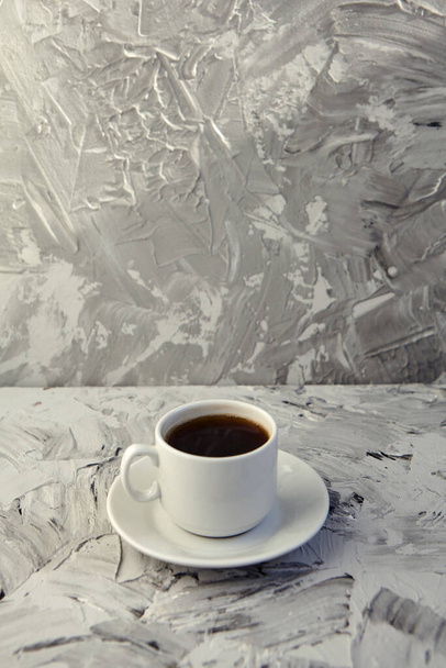 Egy csésze fehér kávé, szürke háttérrel. Forró ital koncepció. Kávézó, eszpresszó, másoló. - Fotó, kép