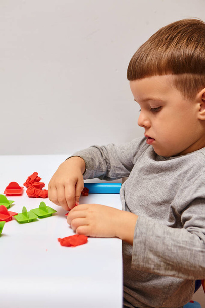 The boy is playing in his room. Young child playing with play doh or play dough. Educational toys for kid's. Games for Child Development.Child's hands kneading modelling clay. - Photo, Image