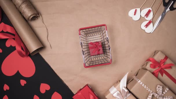 top view of mans hands putting paper heart on a shopping basket. Concept of gifts don valentine. . - Footage, Video