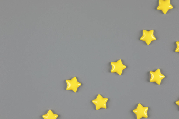 yellow decorative stars sparse on neutral gray background - Foto, imagen
