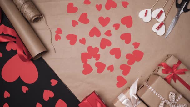 ackground of paper hearts mans hands lay down a small red box. Concept to celebrate valentines day. - Footage, Video