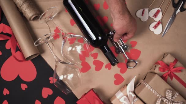 Männliche Hände nehmen eine Flasche Wein und zwei Gläser vom Tisch. Konzept zum Valentinstag - Filmmaterial, Video